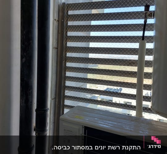 רשת מתכת על חלון למניעת כניסת יונים